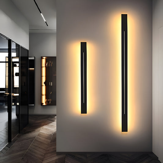 Modern black LED wall sconce with warm lighting, mounted in a hallway