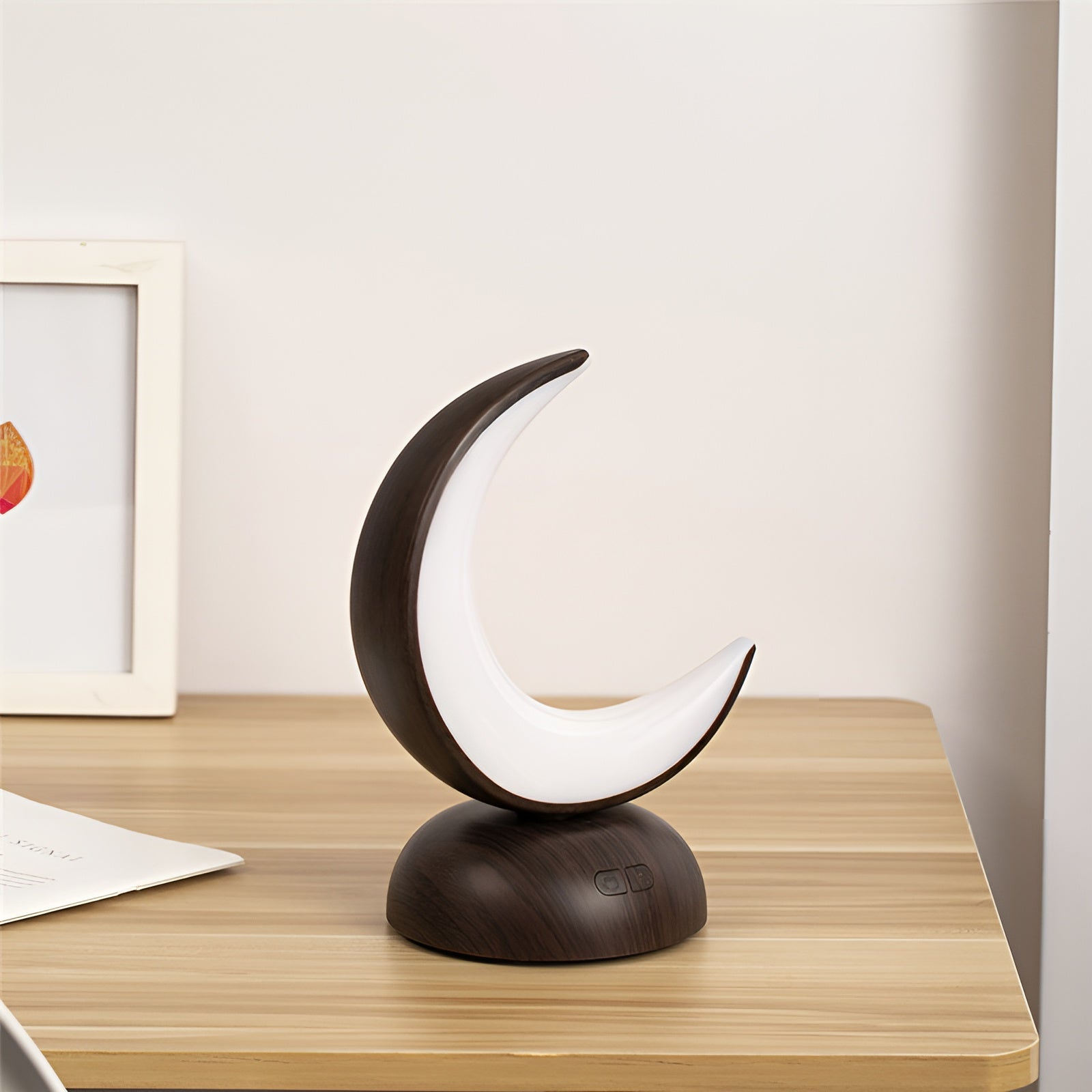Crescent moon-shaped lamp with wooden base styled on desk