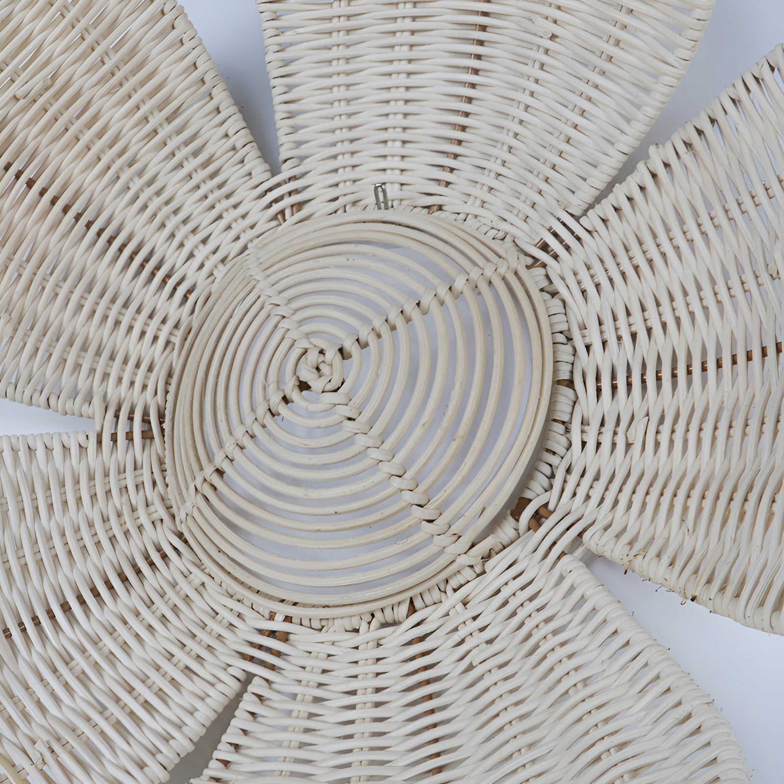 Close-up top-down view of woven rattan flower wall decor showing texture detail